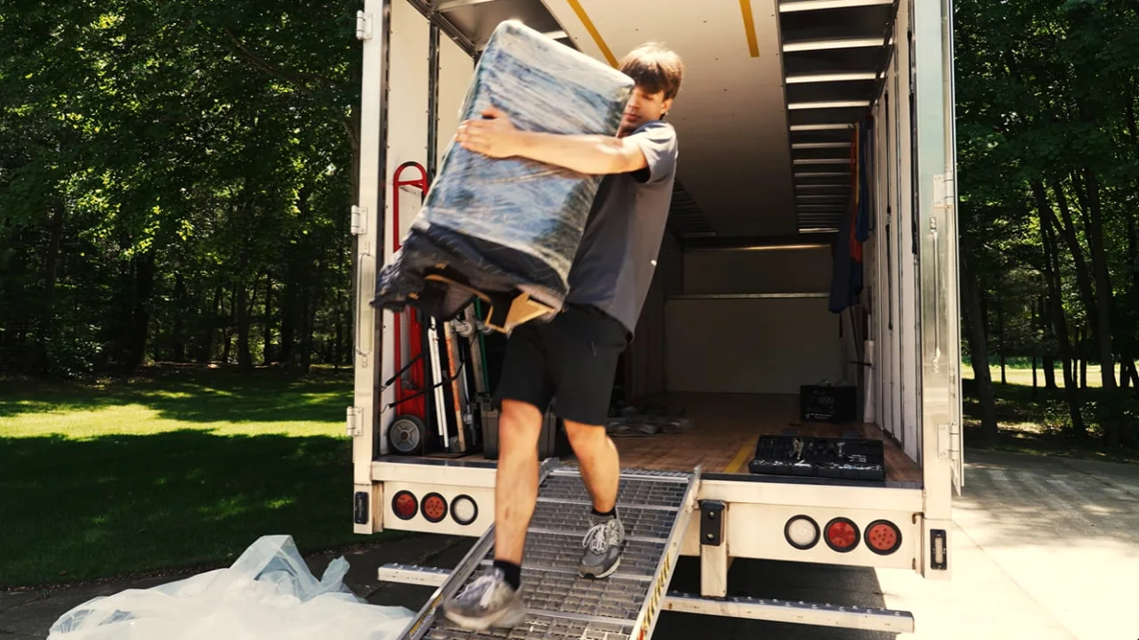 Movers carrying wrapped furniture during a residential move